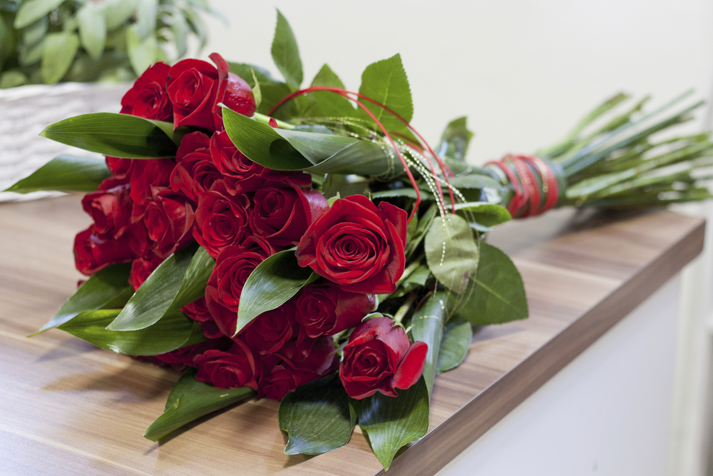 rote Rosen auf einem Holztisch