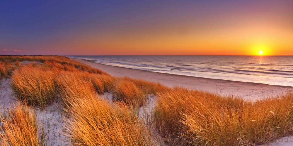Dünen und Strand bei Sonnenuntergang auf der Insel Texel, Niederlande